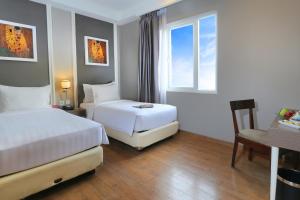 A bed or beds in a room at Pranaya Boutique Hotel