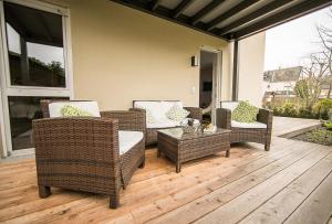a patio with wicker chairs and a table on a porch at Ferienwohnung Laurent in Pünderich