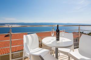 a table with two glasses of wine on a balcony at Apartments Panorama in Lokva Rogoznica