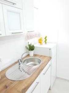 eine weiße Küche mit einer Spüle und einer Theke in der Unterkunft Apartmani Luka & Iva in Šibenik