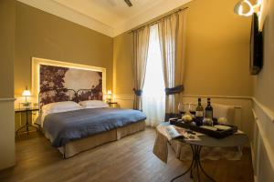 a bedroom with a bed and a table with wine bottles at Locanda di Pietracupa in Tavarnelle in Val di Pesa