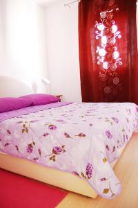 a bedroom with a bed with a pink and white comforter at Good Spirit in Trogir