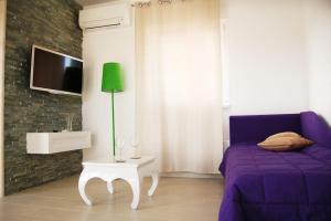 a bedroom with a purple bed and a tv at Good Spirit in Trogir