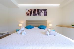 1 dormitorio con 1 cama blanca grande con almohadas azules en Villa Lu sea view-gym-sauna-hot tub,pool, en Mokošica