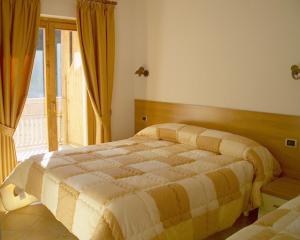 a bedroom with a bed and a large window at Baita dei Pini in Campodolcino