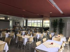 a dining room with white tables and chairs at Verona Tower Hotel in Divinópolis