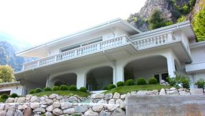 a large white house with a stone retaining wall at Oliveto in Limone sul Garda