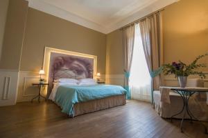 タヴァルネッレ・ヴァル・ディ・ペーザにあるLocanda di Pietracupaのベッドルーム1室(壁に絵画が描かれたベッド1台付)