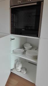a microwave oven sitting on top of a shelf with dishes at l'Intervalle in Mont-Saint-Guibert +18 photos