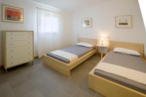 a bedroom with two beds and a dresser at Agriturismo Ca' Tron in Cortellazzo