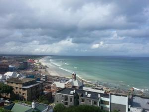 uma vista para uma praia com uma cidade e o oceano em Seaview Apartment in Muizenberg em Muizenberg