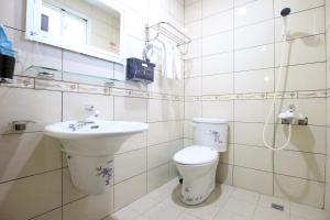 La salle de bains blanche est pourvue de toilettes et d'un lavabo. dans l'établissement Dao Siang Hai B&B, à Taïtung