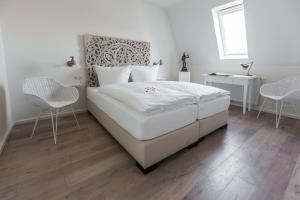 オルデンブルクにあるVilla Sternのベッドルーム1室(大きな白いベッド1台、椅子2脚付)
