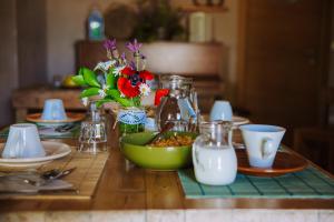 a table with a green bowl of food and flowers at Piccapane Vegan Farm in Cutrofiano +14 photos