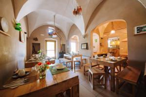 a dining room with wooden tables and chairs at Piccapane Vegan Farm in Cutrofiano