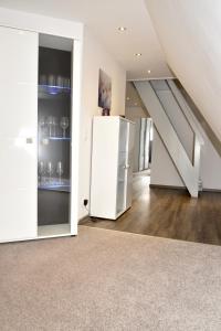 een witte koelkast in een kamer met een trap bij Ferienwohnung Brigitta in Hambühren