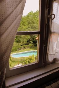 a window with a view of a swimming pool at Casa de Encosturas in Cabeceiras de Basto