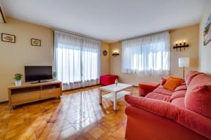 uma sala de estar com um sofá vermelho e uma televisão em Vivalidays Casa Genis em Palafolls