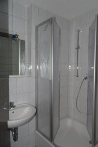 ein Bad mit einer Dusche und einem Waschbecken in der Unterkunft Monteurzimmer Aschheim in Aschheim