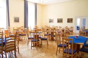 a room full of tables and chairs with blue table cloth at Waldschloss Parow in Ostseebad Koserow