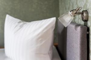 a lamp on the side of a bed with a pillow at Villa Stern in Oldenburg