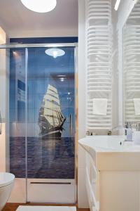 a bathroom with a shower with a ship in the window at Sun Apartament - Królewskie Kamieniczki in Sopot