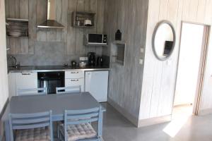 a kitchen with a table and a table and chairs at Le grenier a sel in Marennes