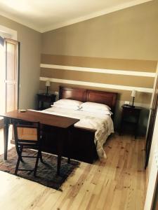 1 dormitorio con cama y escritorio de madera en Bed & Breakfast Le Piagge, en Scurcola Marsicana