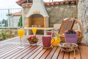 einem Holztisch mit zwei Gläsern Orangensaft in der Unterkunft Apartment Ortensia Dubrovnik Colors in Dubrovnik