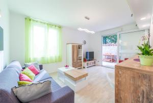 ein Wohnzimmer mit einem Sofa und einem Tisch in der Unterkunft Apartment Ortensia Dubrovnik Colors in Dubrovnik