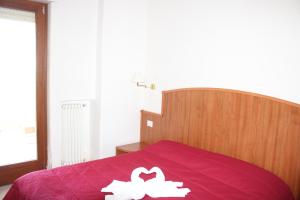 a bedroom with a purple bed with a white flower on it at Residence Hotel Torresilvana in Vieste