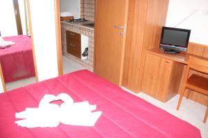 a room with a pink bedspread with two white birds on it at Residence Hotel Torresilvana in Vieste