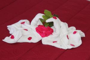 two white towels with a rose on a bed at Residence Hotel Torresilvana in Vieste