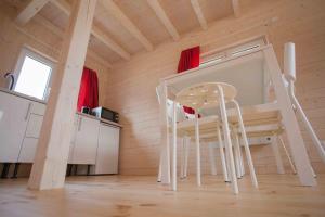 a room with a table and chairs in a tiny house at fajnemorze - Domy Szwedzkie in Dębina-Ustka