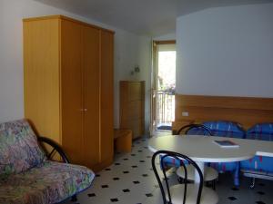 un soggiorno con divano, tavolo e sedie di Residence San Vito a Brenzone sul Garda