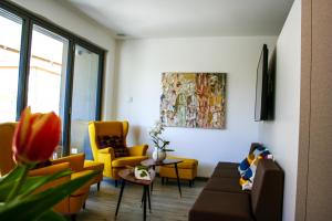 リーヴァ・デル・ガルダにあるGardaBreak Rooms&Breakfast Holiday Apartmentsのリビングルーム(黄色の椅子、ソファ付)