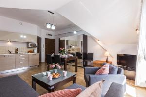 a living room with a couch and a table at Apart Styl Apartament Radowid z basenem, centrum miasta in Zakopane