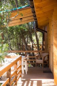 eine Veranda einer Hütte mit Stühlen und einem Tisch in der Unterkunft Elbadoc Camping Village in Cavo