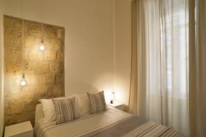 ナポリにあるB&B EMME21の石壁のベッドルーム1室(ベッド1台付)