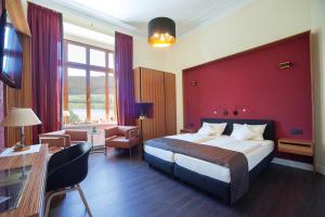 a hotel room with a bed and a red wall at Weinhotel St. Stephanus in Zeltingen-Rachtig