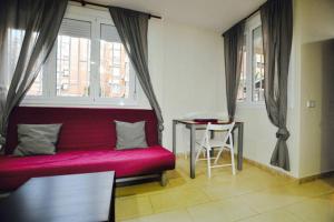 a living room with a red couch and a table at Apartment Downtown Sabadell in Sabadell