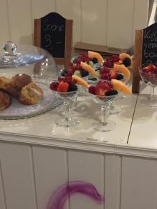 a table topped with glasses of fruit and pastries at Villa D'este in De Haan