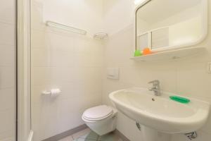 a white bathroom with a toilet and a sink at Dünenhaus Sellin in Ostseebad Sellin +93 photos