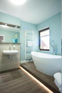 a bathroom with a white tub and a sink at Weinhotel St. Stephanus in Zeltingen-Rachtig