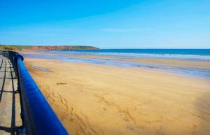 a view of a beach with a blue pipe on it at St Kitts Holiday Apartment in Filey