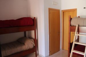 a room with three bunk beds and a door at Residence Hotel Torresilvana in Vieste