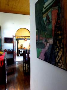 soggiorno con un dipinto appeso a una parete di Pouso das Glicínias - B&B a Ouro Preto