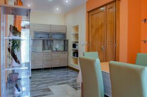 a kitchen with orange walls and wooden cabinets at Harmónia Apartmanház in Eger