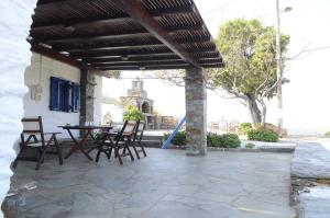 a patio with a table and chairs under awning at Traditional Farmhouse in Kea in Pisses