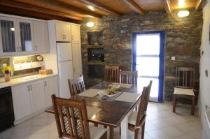 a kitchen and dining room with a table and chairs at Traditional Farmhouse in Kea in Pisses